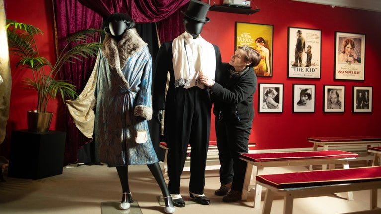 Charlotte, assistant to the costume curator, adjusting a scarf